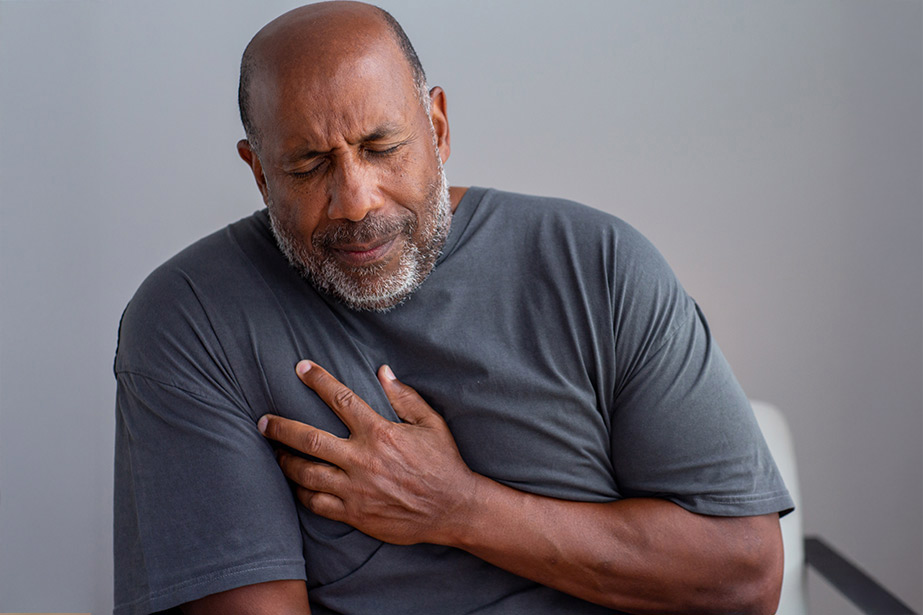 Man grimacing while holding chest