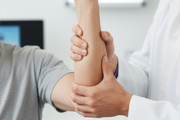 doctor examining the elbow of a patient