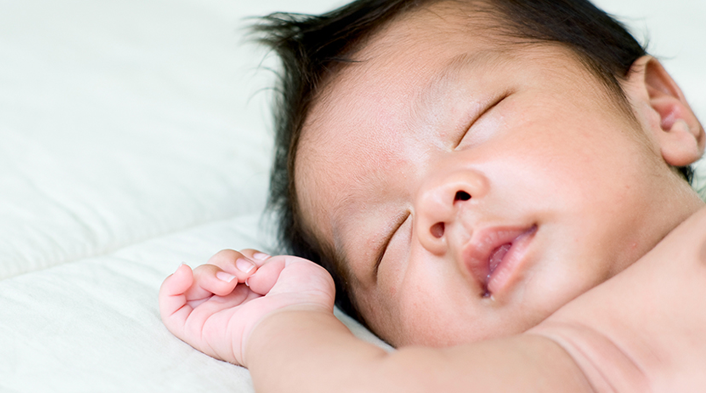Hispanic baby boy sleeping on back on flat surface