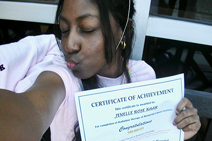 Jenelle holding radiation therapy certificate of achievement